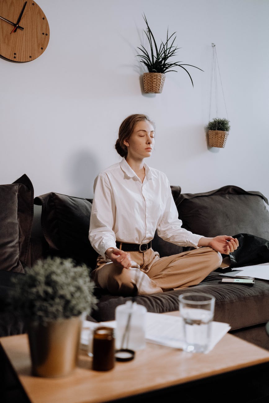 A business woman is meditating in her couch